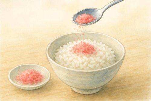 ごはんに桜でんぶをふりかけている。