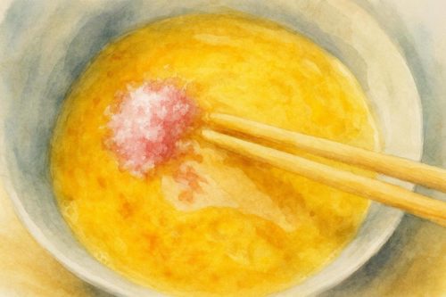 溶き卵に桜でんぶを投入している