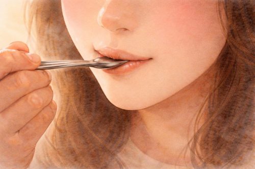 スプーンですくったバナナを口に含んでいる人