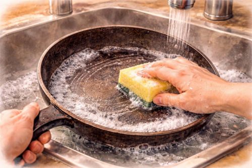 テフロン加工のフライパンをスポンジで洗っているシーン