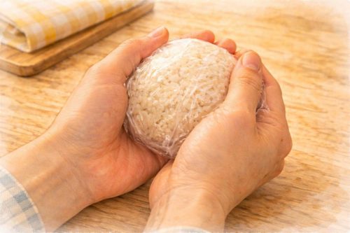 ラップで包んでおにぎりを握っているシーン